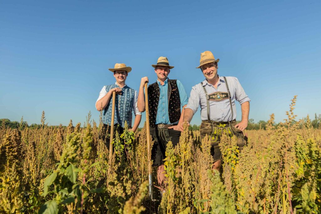 Drei Bauern lachend auf einem Quinoa Feld